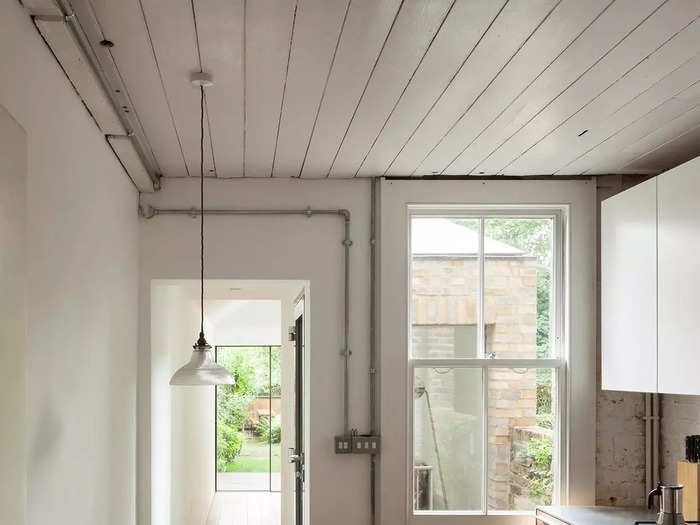 Per the floor plans, the ground floor opens up into a long kitchen, which is fitted with wooden cabinets, a stovetop, and an oven.