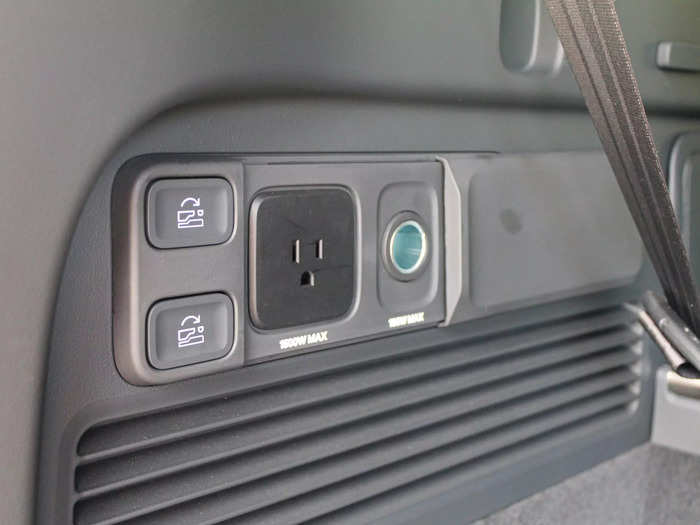 The left wall of the Rivian has two electrical outlets behind a sliding plastic cover.