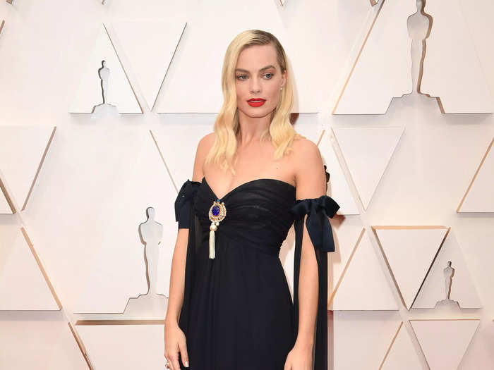 At the 2020 Oscars ceremony, Robbie wore a timeless, black satin maxi dress with a blue-and-gold brooch in the middle.