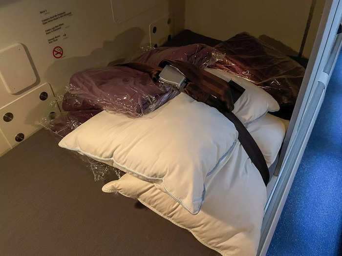 Each bed has a seat belt for potential turbulence, with blankets and pillows strapped underneath.