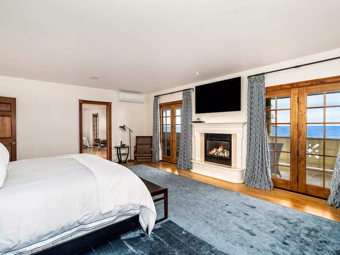 The primary bedroom has its own fireplace and access to the second-floor balcony.