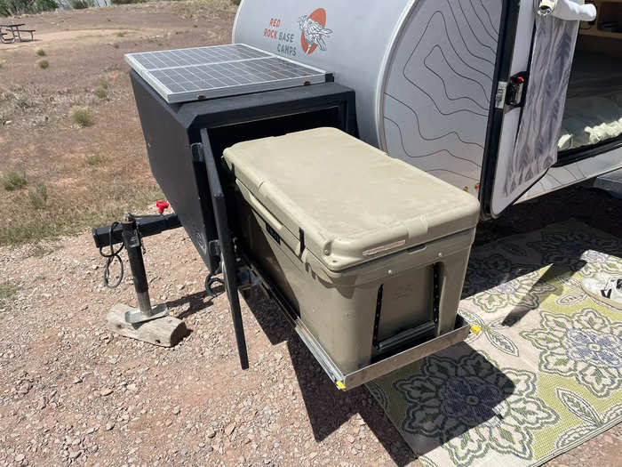 Outside of the camper were more amenities to make camping a breeze. At one end, a pull-out nook came with a cooler and solar panel.