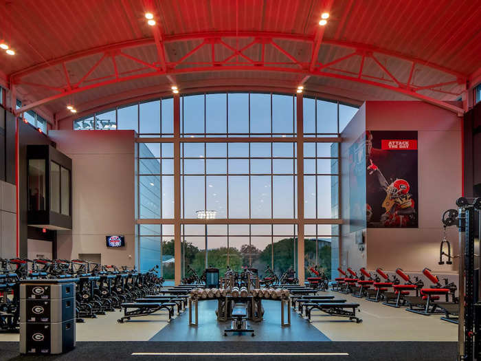 Floor-to-ceiling windows overlook the outdoor training fields and fill the weight room with natural light.