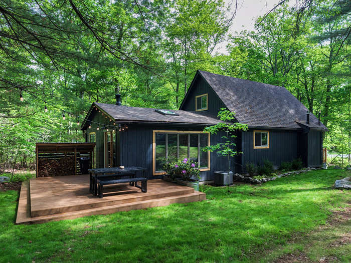 The chalet, located steps away from the cabin, is painted in the same dark blue shade with yellow accents.