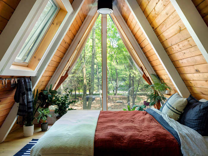 The bedroom is in the loft, next to a custom-designed triangle glass window.