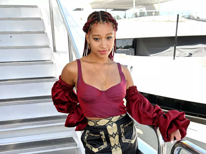 Amandla Stenberg looked chic in a burgundy top with detached sleeves and a multi-fabric skirt.