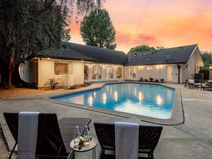 The backyard has a pool and large patio, and a two-car garage is attached to the home.