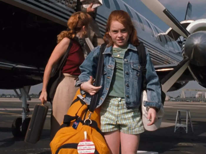 Now, for Annie-as-Hallie — she hopped off the plane at Napa Valley with a yellow duffel, green gingham shorts, a matching green T-shirt, and a denim jacket.