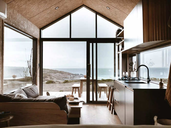 Inside, the tiny cabin has large windows with direct views of the coast, making the small interior feel spacious.