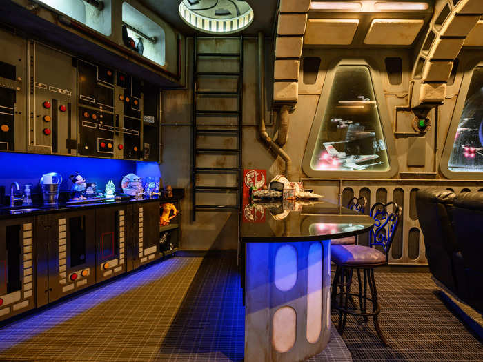 A space-themed bar is located at the back of the home theater.