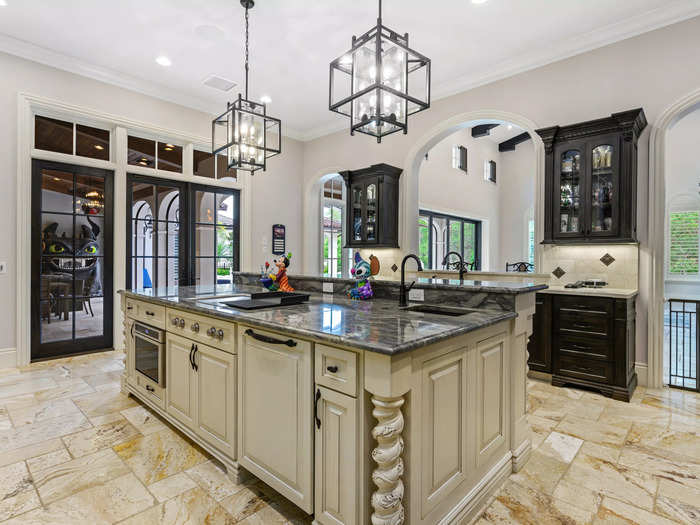 The kitchen has custom-designed cabinetry and a large island with granite countertops.