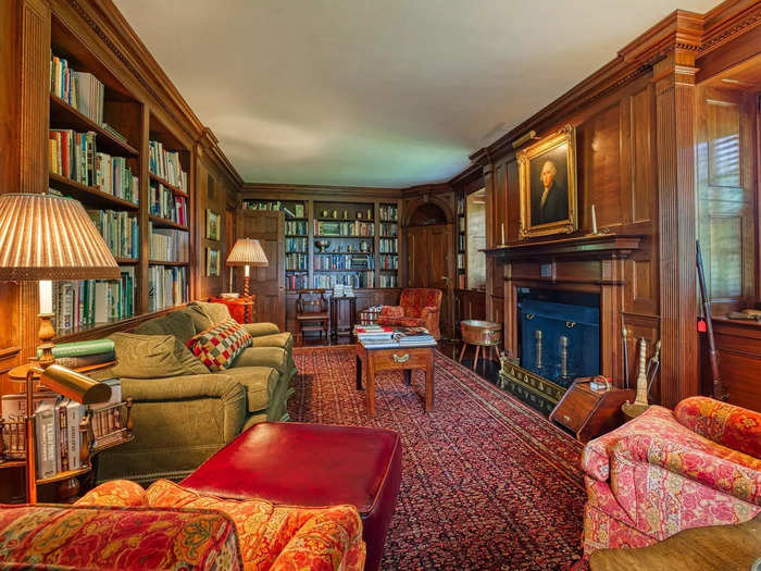 The wood-paneled library comes with built-in shelves and a fireplace.