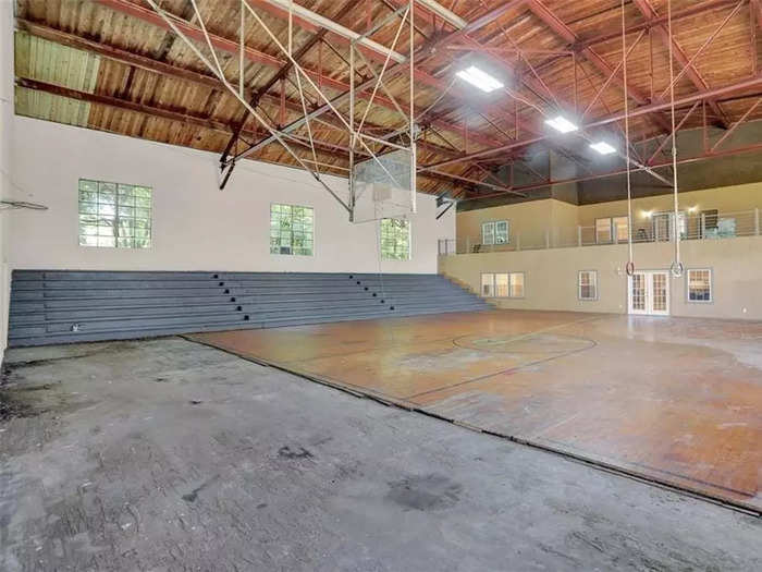 The building is now split into two distinct halves: One half still looks and feels like a gym, replete with bleachers and high ceilings. The other half, which is behind the mustard-colored wall in the photo below, looks and feels like a home, with segmented rooms and two levels.