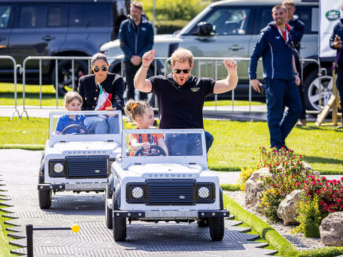 Harry raised his arms to cheer as he and Markle accompanied young children on mini-cars at the Invictus Games in April.