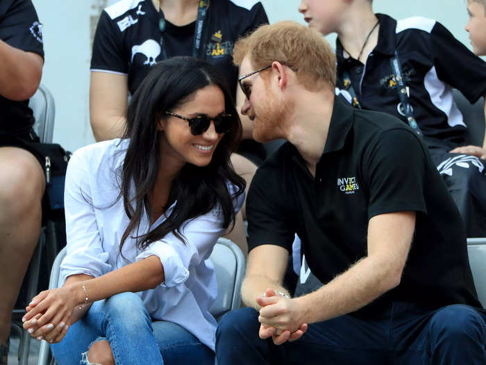 Prince Harry leaned in toward Meghan Markle to tell her something during their first appearance as a couple in 2017.