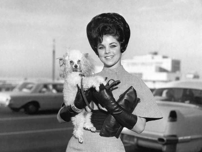 Priscilla Presley was photographed at the Memphis International Airport in 1963 wearing a dress and matching cape with leather gloves.