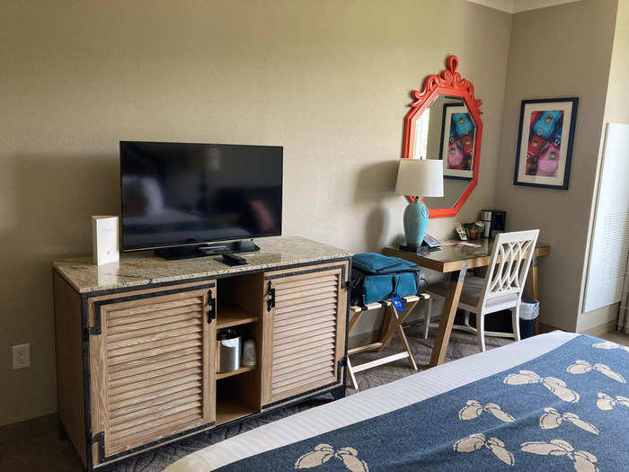 In addition to a small seating area, the room featured a TV, refrigerator, and desk.