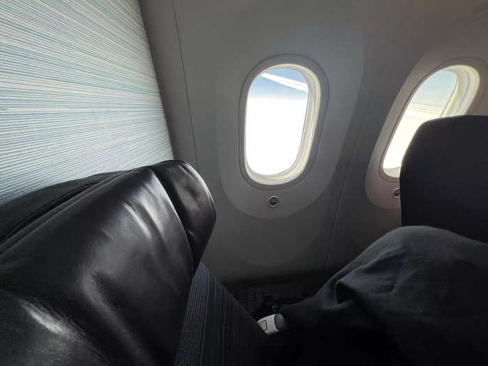 Technically, the middle seat was a window, though there was a large gap between it and the fuselage wall. Nevertheless, the open space was the perfect spot to stow my duffle bag.