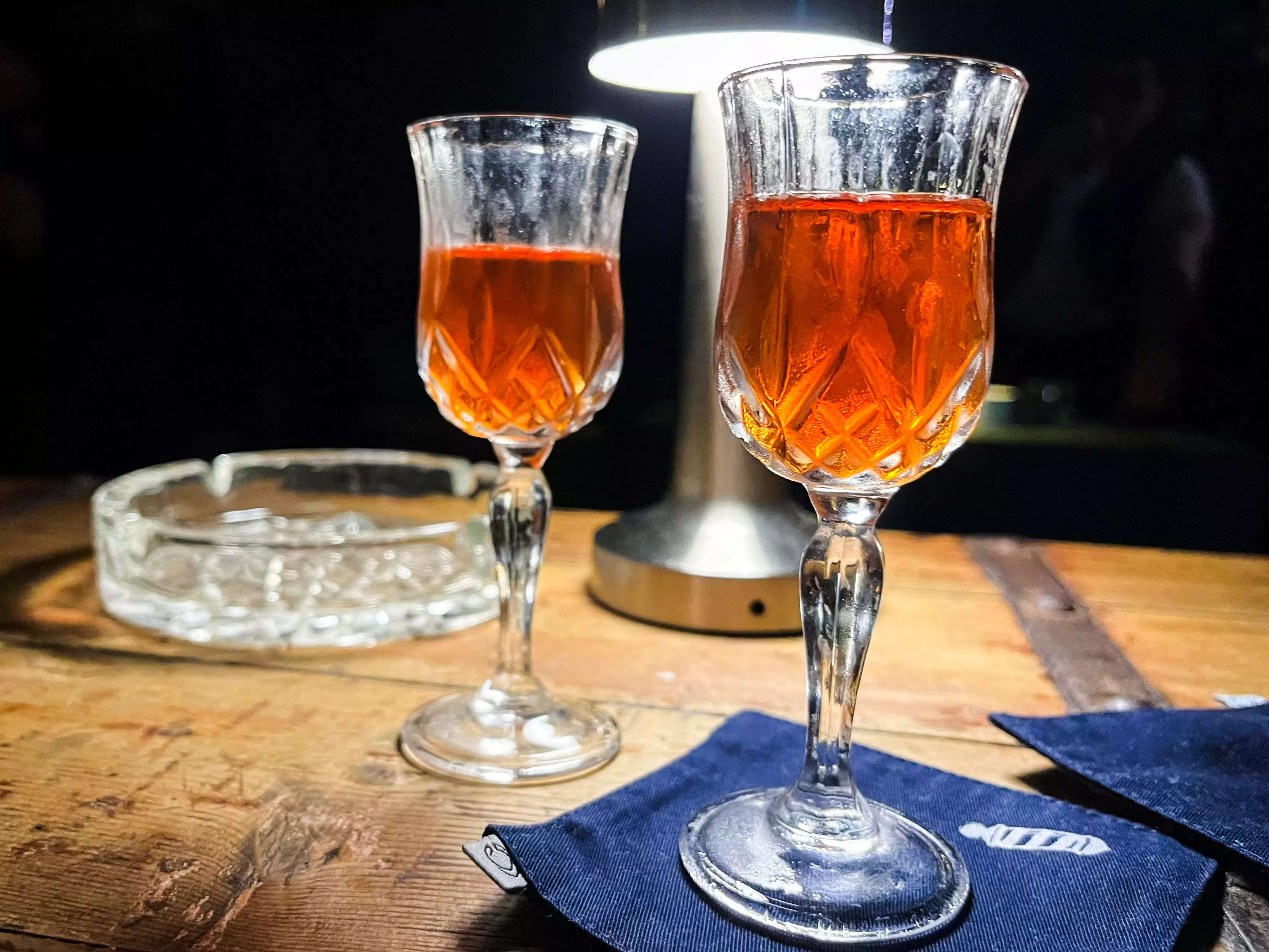 Two Negroni cocktails from The Barbershop Speakeasy in Rome on a table.