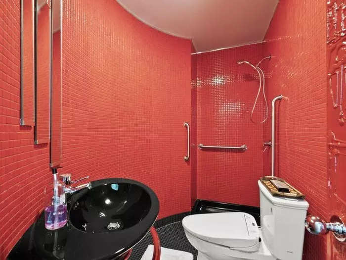 There are four bathrooms in total, and they also feature the red, black, and white color scheme.