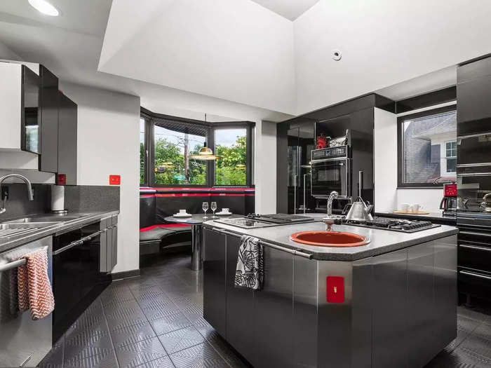 The kitchen, which is on the second floor, is fitted with red-and-black appliances and cabinetry.