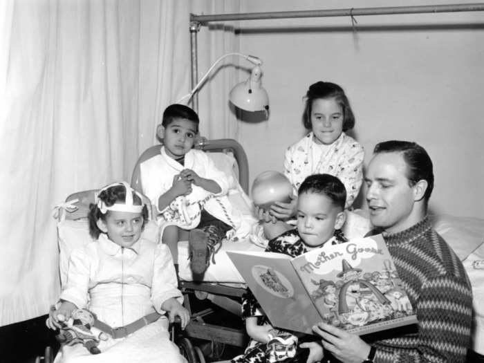 January 1956: Actor Marlon Brando reads to children with polio.