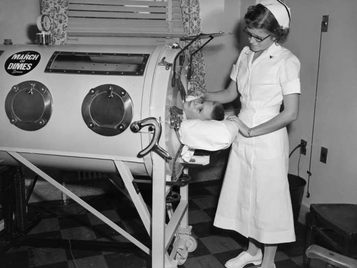 1955: A nurse oversees a boy with polio in an iron lung.