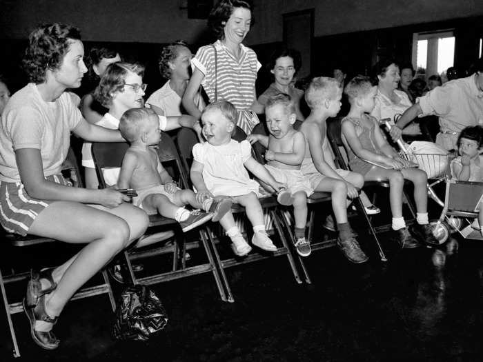 July 2, 1952: Mothers in Houston, TX wait with their children to be inoculated with gamma globulin to prevent paralysis from polio.