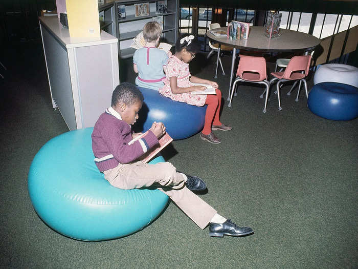 1968: Children read books in a school library in Queens, New York.