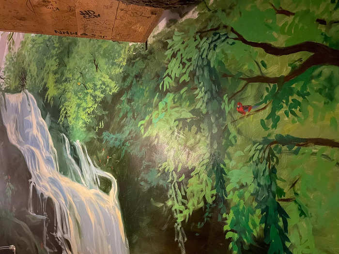 The theme continued along the walls of the room. Two walls were covered in colorful murals. One wall was covered in palm trees and the other looked like a rainforest with lush greenery and a waterfall.