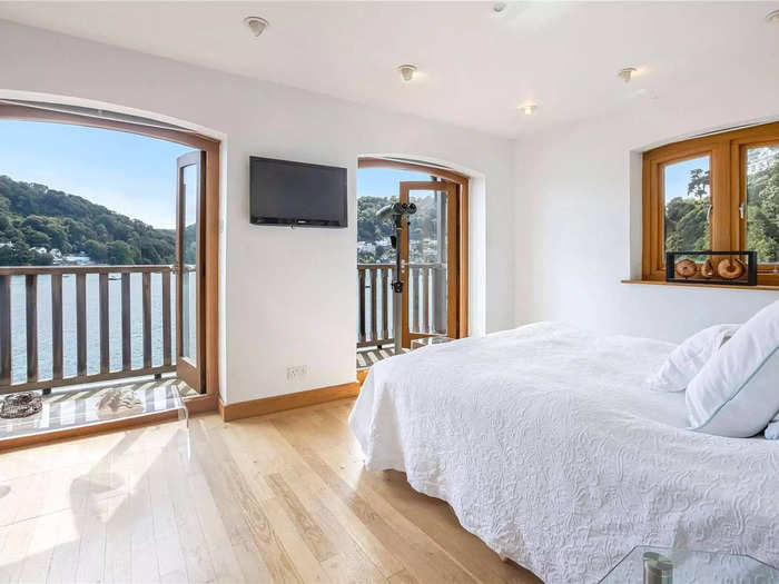 This bedroom has oak flooring and double doors with views of the River Dart below.