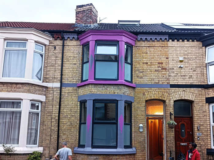 On the outside, Sharples kept the exposed brick facade and painted her bay windows pink and purple — although this "is not how it