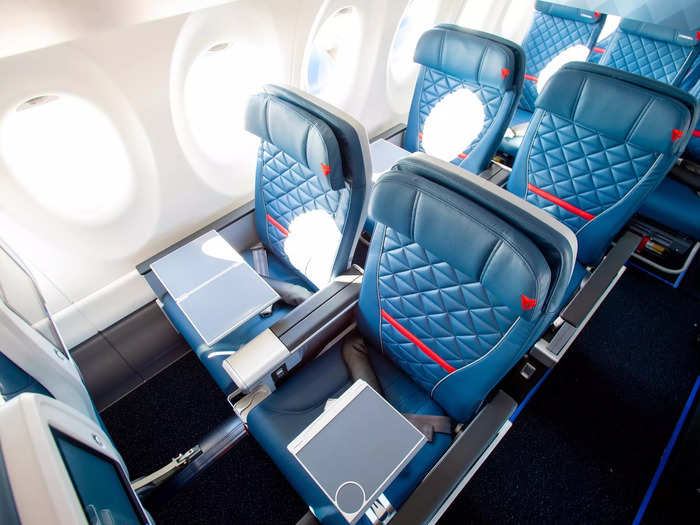 First class is configured in a 2x2 layout with tray tables in the armrest...