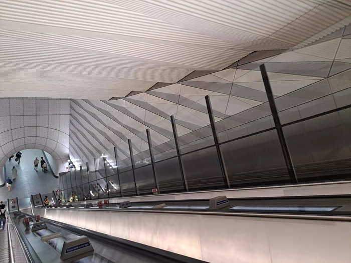 The elevators are separated from the escalator by a glass screen.