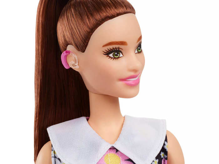 One of the new Barbie dolls has a hot-pink hearing aid, clearly shown by her hair scraped back in a ponytail.