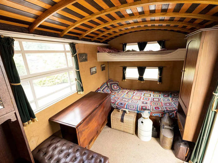 Behind the couch is a living space with four sleeping spots, a wood-burning stove, and plenty of storage.