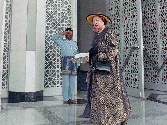 1989: An attendant at the Sultan Salahuddin Abdul Aziz Shah Mosque saluted the Queen during her visit to Kuala Lumpur.