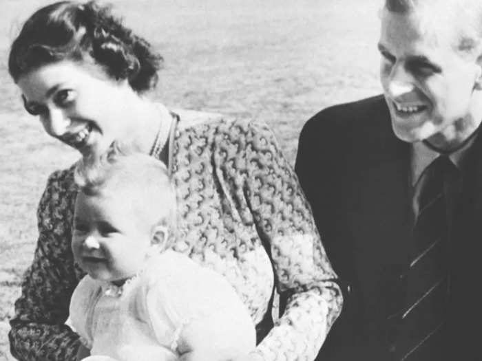 1949: Here, an 8-month-old Prince Charles is cradled by his mother on a warm July day.