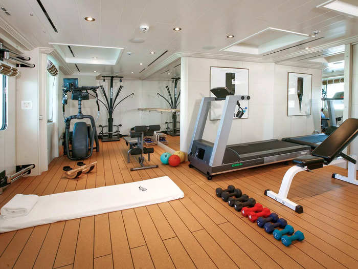 The gym features weights, a treadmill, and other equipment.