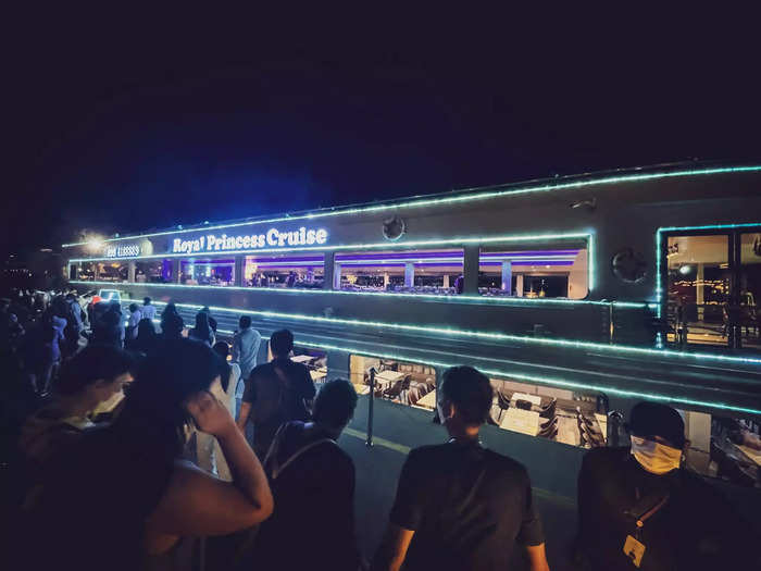 The Royal Princess Cruise, my dinner cruise for the night, arrived at dusk. It was a relatively small ship with an open upper deck. It was glowing in the dark, with strips of blue light running across the exterior. It looked like a souped-up ferry.