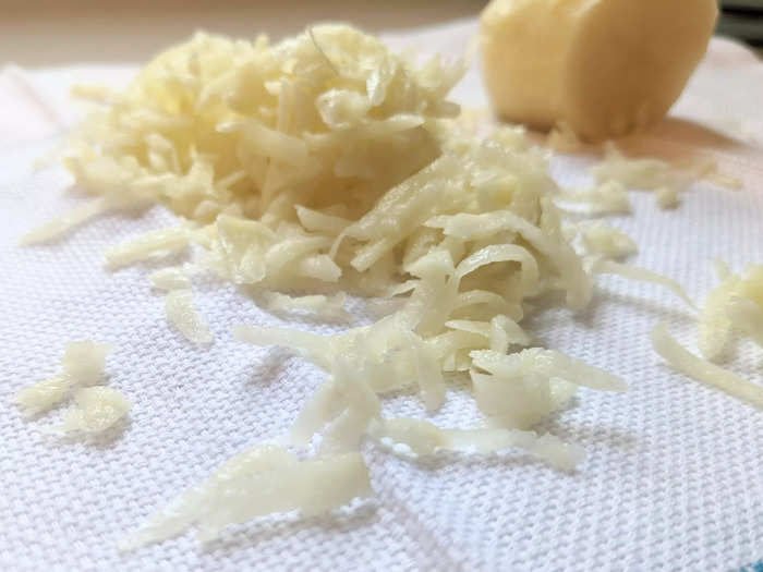 Grate the remaining potatoes onto a clean tea towel.