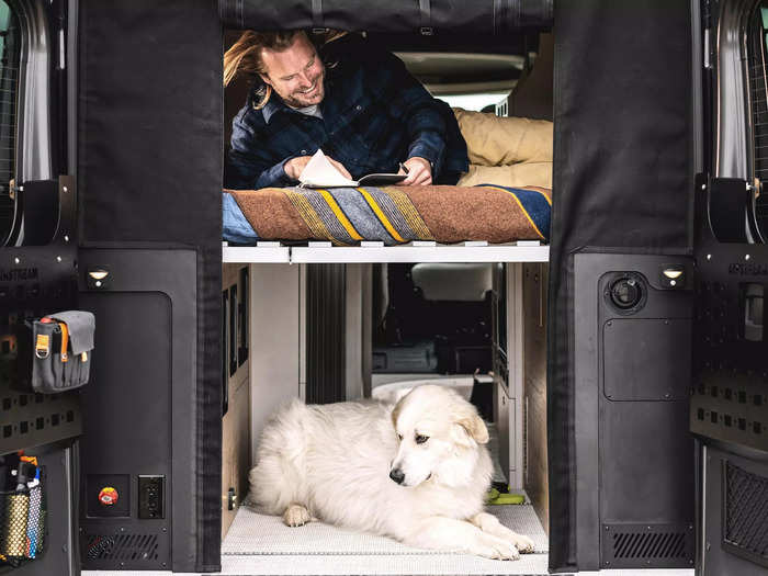 To accommodate this many travelers at night, the camper van has a rear folding twin bed above the garage …
