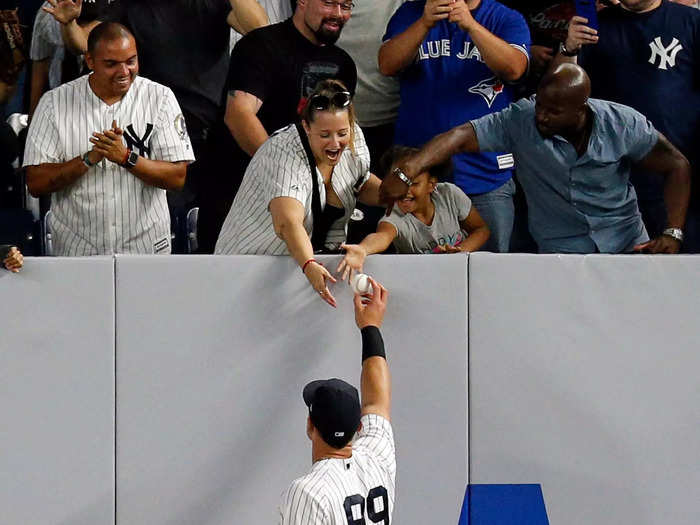 Handing balls to fans over the 8-feet-tall wall is not a problem for Judge.