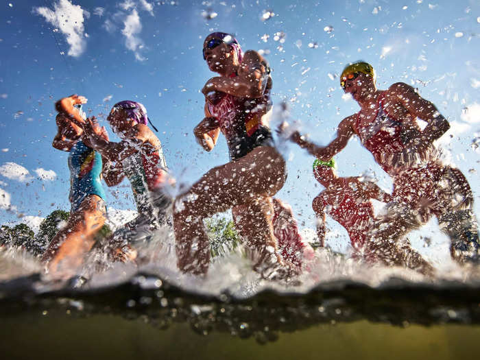 8/12: A pack of athletes compete in the swimming stage of the Women