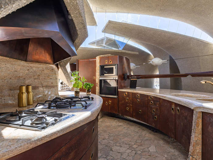 The kitchen, which is built between massive, unmoved boulders, is designed in a semi-circle.