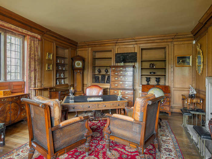 The first reception room has a table, armchairs, and a fireplace, giving the space a cozy feel.