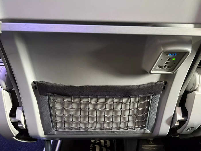 Despite lacking inflight screens, the seats did have a few amenities, like seatback pockets and a conveniently placed power outlet...