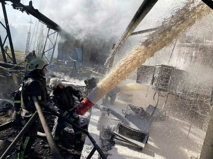 Firefighters hose down a piece of infrastructure that was damaged by the strikes in Kyiv.