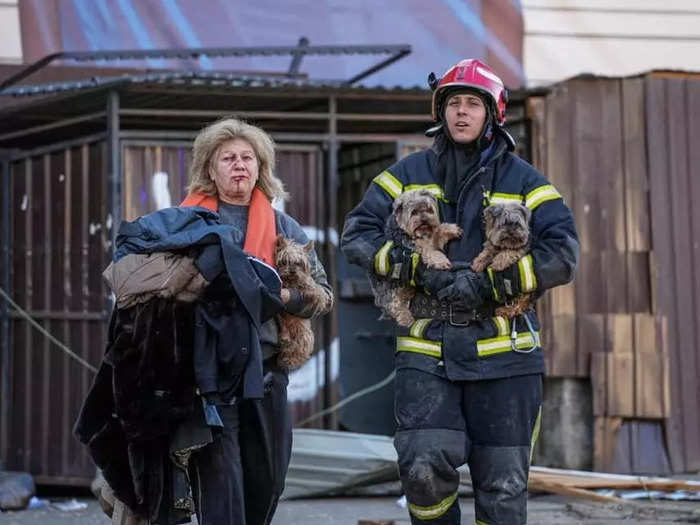 A rescuer helps an injured woman carry dogs after a Russian missile strike on an unknown location in Ukraine.