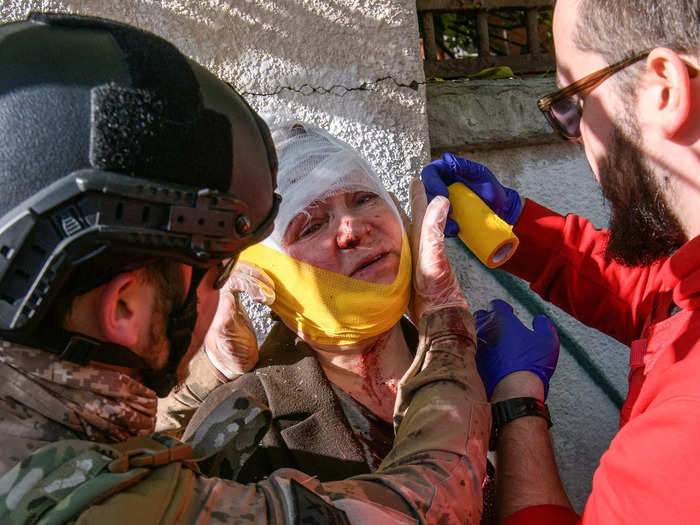 An injured woman receives medical attention at the scene of Russian shelling in Kyiv.